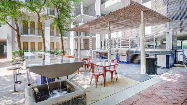 Apartment community outdoor lounge and grilling station at Griffis Uptown in Dallas, TX.